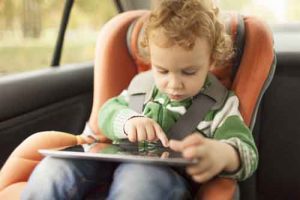 Enfant en voiture jouant avec une tablette