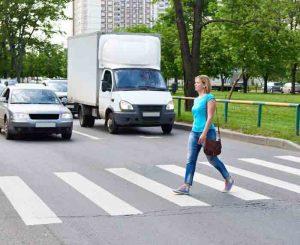 Woman crossing the street at pedestrian crossing