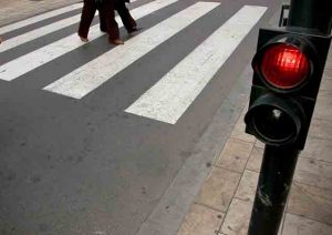 People crossing the road at red light on pedestrian crossing