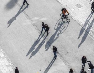 people walking at the street with long shadows